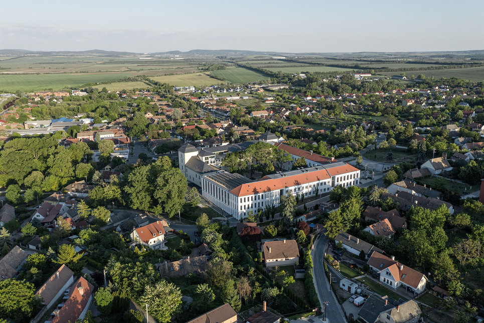 Keresztelő Szent János Iskolaközpont, Zsámbék, az iskola a premontrei templom felől nézve –  terv: Kovács Zoltán, Golda János, Csontos Gyula, Kollektív Műterem, 2019 – fotó: Danyi Balázs