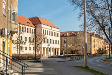 Az előbbire merőlegesen indul, és a városkapun túl végződik a városközpont másik tengelye, a Fürst Sándor utca, amelynek belső szakasza ma már helyi védelem alatt áll. A baloldali sarokerkély mögött az általános iskola világos épülete.