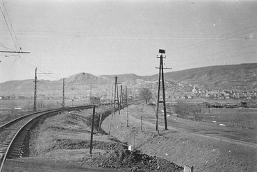 A Budapest-Törökbálint között közlekedő HÉV vonala a budaörsi Kinizsi utcai átjárónál, szemben a Templom téri Nepomuki Szent János-templom, 1960. Forrás: Fortepan / Belházy Miklós