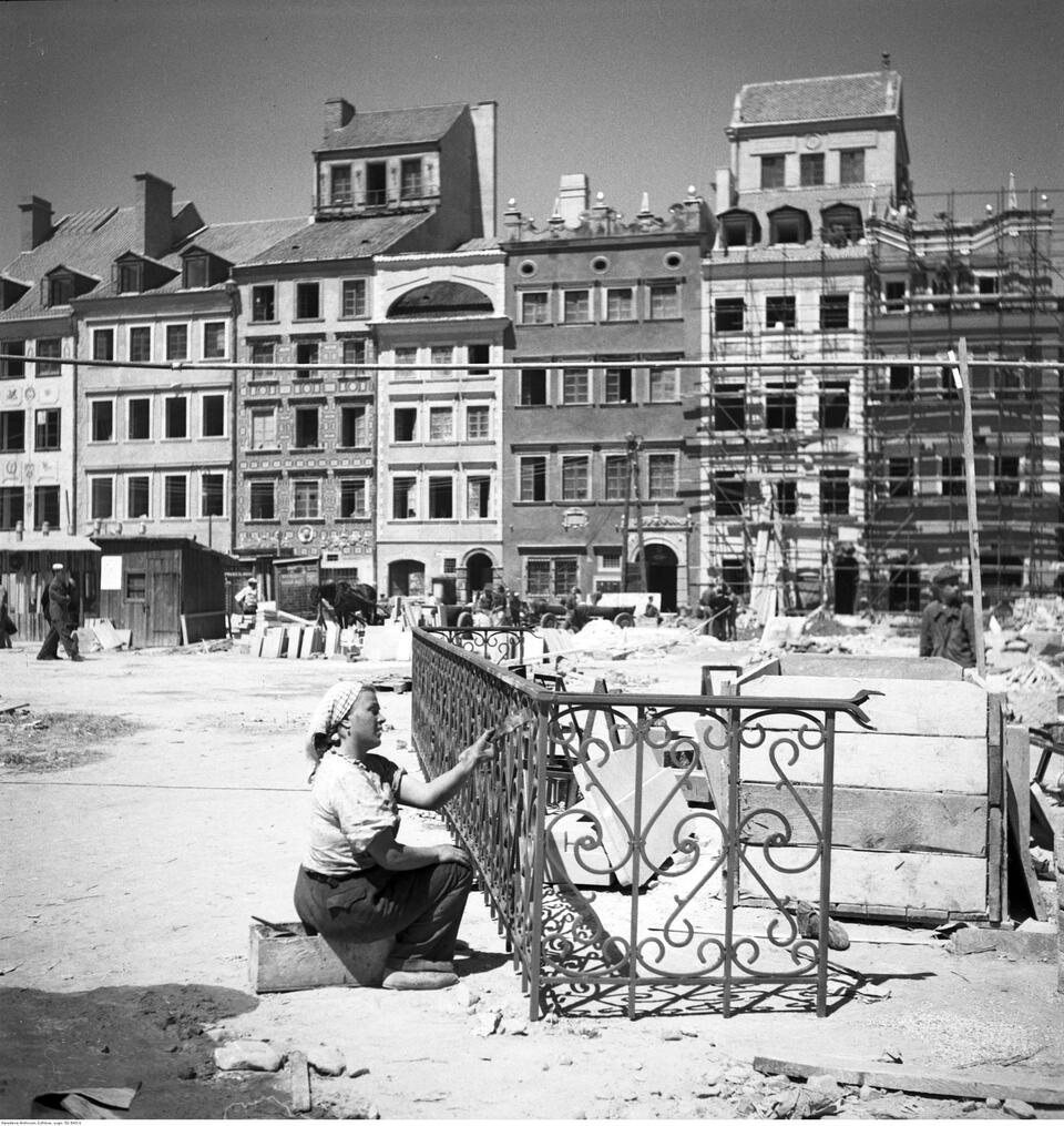 Munkában lévő hölgy, aki az egyik erkély rácsát festi, Fotó: Zbyszko Siemaszko, 1953, Narodowe Archiwum Cyfrowe