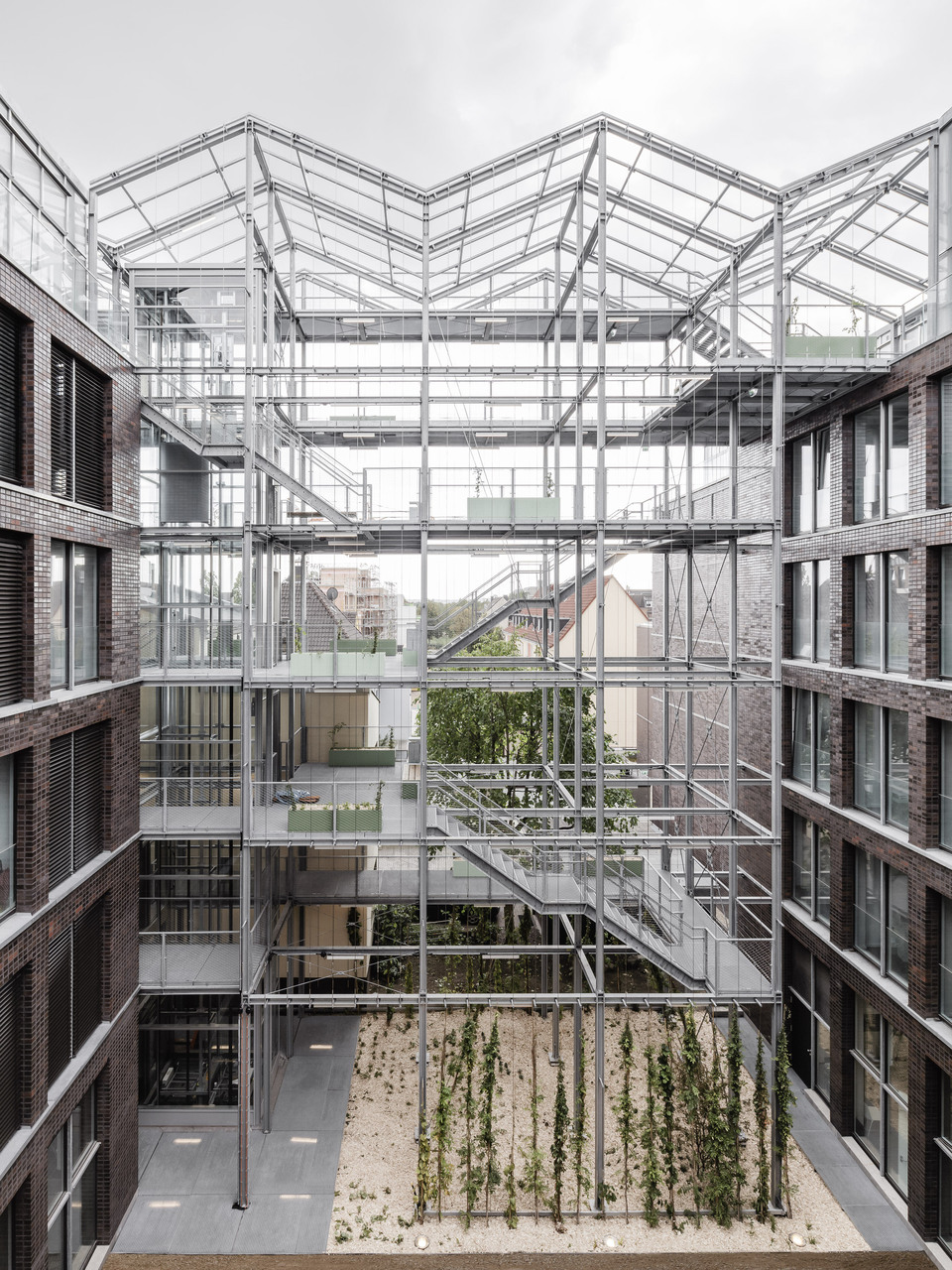 A belső udvar nézete a vertikális üvegházzal a háttérben – Kuhen Malvezzi: Munkaügyi központ és termelőház. Fotó: Hiepler, brunier,