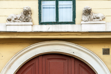 A fogadó, amelynek névadó oroszlánjai ma is őrzik a bejáratot, főként az Alföldről jött kereskedők közt volt népszerű, akik a közeli Kecskeméti kapun léptek be a város területére. Ma a Károli Gáspár Református Egyetem igazgatósága működik az emeleti falak közt.
