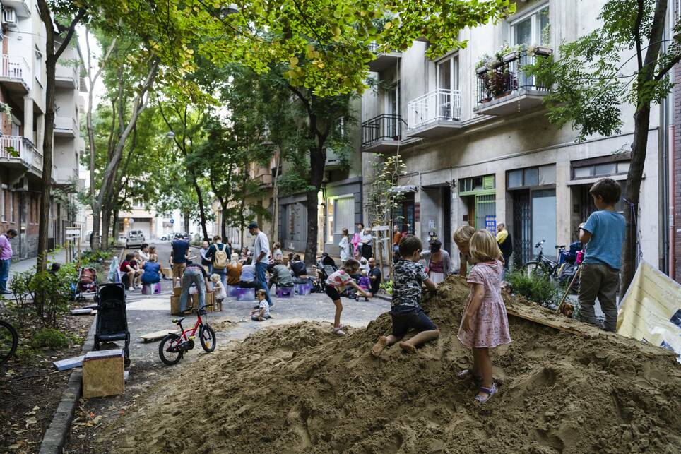 Bogyó Virág és Madácsi Flóra Játszóutca?! című projektje, ami a Flaszter: 1. Budapesti Köztéri Kortárs Művészeti Biennále keretében került megvalósításra. A program során 2023 őszén egy hosszú hétvégére játszóutcaként újranyílt a Barát utca. Az utca közepén egy óriási homokdombot és mobil játszóelemeket helyeztek el a szervezők. Fotók: Bognár Benedek, Simon Zsuzsanna  / BTM Budapest Galéria / FLASZTER. Forrás: @jatszoutcakat__budapestre 
