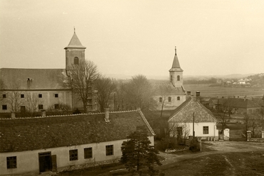 Ajka belvárosának látványa a Templomdombról az 1970-es évek elején. A fotó egyesített, felújított változatán jól látszik a kórház és az első panel épületek sziluettje, valamint a szölőhegy szinte üres oldala. / Ajkai Fotóklub, Sipos Ottó 