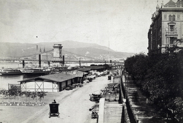 Teherkikötő és áruraktárak a pesti rakparton 1900-ban. Villamos és viadukt még nincs, felső rakpart és lejárólépcsők már igen. Érdemes megfigyelni a Lánchíd eredeti, karcsú vasszerkezetét is. Forrás: Fortepan / Budapest Főváros Levéltára / Klösz György