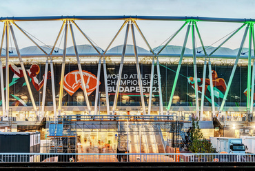 A nézők és sportolók hadának kiszolgálásán a háttérben egy kisebb városnyi szakember dolgozik. A stadion tetőzete alatt, óriási, logókkal ellátott fekete háló mögött tárul fel az ősszel lebontandó, ideiglenes lelátó.
