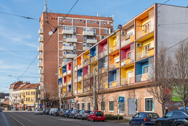 A város központjának szabad telkein is egymás után jelentek meg az egyedi tervezésű, városképi jelentőségű új épületek. A Búza térrel szomszédos kétrészes lakótömb Krisztik Pál tervei alapján, röviddel a szocreál kora után, 1958-59-ban épült, immár egész más megközelítésű díszítéssel.
