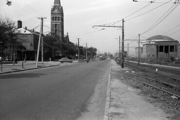 Kerepesi út, balra a Százados út torkolata és a Lisieux-i Szent Teréz-templom (Törökőri templom). Jobbra a metró és a gödöllői HÉV Hungária körúti, közös végállomása (később lebontásra került). Előtte az ekkor a Keleti pályaudvarig közlekedő HÉV vonala. A felvétel a 3-as főút szélesítéséhez kapcsolódó sorozat része, 1961. Forrás: Fortepan / FŐMTERV
