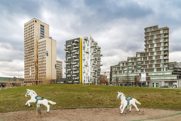 A lassan formálódó központi park szélén 2020-ra készült el a 84 méter magas HoHo Wien toronyház (balra). Bár építői a világ harmadik legmagasabb fa épületének tartják, belső magja, a liftaknákkal és a lépcsőházakkal még vasbetonból készült, a külső pillérváza azonban mind a 24 szinten lucfenyőből.

 
