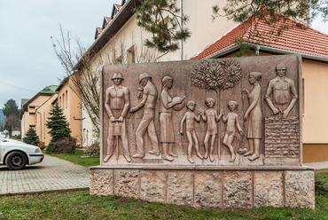 Az iskola mellett 1986 óta áll a helyi szobrászművész, Vörös Gábor több mint négy tonnás domborműve, ami az akkor még Tardosbánya nevű falu mindennapjainak állít emléket.
