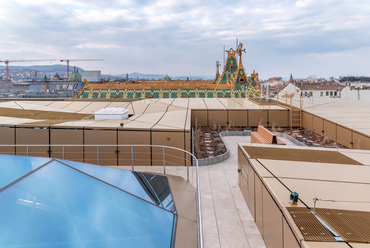 A Postatakarékpénztár Zsolnay majolikái találkoznak az arany bádogtetővel. Sűrű gépészet, kis kertszerűségek és pazar panoráma. A tetőn is körbejárható az üvegezett belső udvar.
